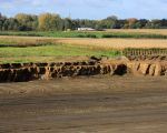 Het witte huis bovenaan de foto is de 'Overslag' aan de Belgische kant van de Maas. Op deze foto is duidelijk te zien hoe de graafmachines de dekgrond meter voor meter afgraven. De grond tot aan het witte huis in de verte zal nog geheel worden afgegraven.  (24-10-2010 - Jan Dolmans)