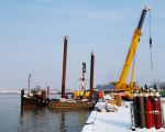 Een ponton-met-poten, zgn. spudpoten waarmee de ponton op de onderwaterbodem kan staan, wordt gereed gemaakt. Dit ponton is nodig bij het weer op de gewenste diepte brengen van de werkhaven.  (3-12-2010 - Reen van Beek)