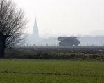 Dumper op weg naar de locatie Borgharen. Op de achtergrond de kerk van Borgharen. (1-3-2011 - Jan Dolmans)