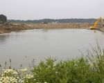 Aan de rechterkant wordt ontgrind en aan de linkerkant wordt het onstane gat alweer gevuld met afgegraven dekgrond vanuit de bochtverbreding langs de Maas.  (20-5-2011 - Jan Dolmans)