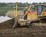 Achter de bulldozer zie je hoe de Maasoever verlaagd wordt.  (20-5-2011 - Jan Dolmans)