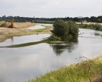 Foto genomen vanaf de oever te Smeermaas met het begroeide grindeiland in het midden van de Maas. De Maasoever ter hoogte van Smeermaas zal in de komende tijd extra worden verstevigd omdat men bang is dat de oever door de Maas, bij hoogwater, steeds verder wordt uitgehold. Onlangs heeft men de struiken langs de Maas al verwijderd.    (8-6-2011 - Jan Dolmans)