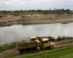 Op de voorgrond rijden de dumpers aan Belgische zijde en bovenaan de foto de Nederlandse kant.  (19-8-2011 - Jan Dolmans)