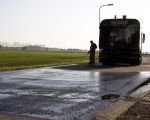 Bij de toegangen naar het fietspad heeft het Consortium verkeersdrempels in de  weg gemaakt om het doorgaande verkeer enigzins op die plaatsen af te remmen. Voordat de bitumenlaag wordt aangebracht wordt eerst vloeibaar teer op de weg gespoten als een soort lijm.  (9-11-2011 - Jan Dolmans)