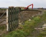 Het hek dat jaren lang toegang gaf tot de moestijn van Hub Beenkens hangt er verlaten bij, als een herinnering aan het verleden, terwijl aan zijn voeten de goede tuingrond al is weggegraven.  (6-3-2012 - Jan Dolmans)