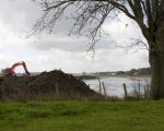 Zoals je ziet is de graafmachine al tot aan de bomenrij, die het laatste stukje groen achter de kapel in Itteren omzoomd, gevorderd.  (11-4-2012 - Jan Dolmans)