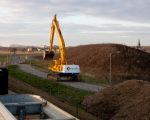 De graafmachine kan niet onder het tunneltje door, daarom wordt even een omweg gemaakt.  (18-3-2013 - Jan Dolmans)