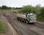 Vrachtauto's rijden af en aan met grond richting Geulle. Op deze foto aan de voorzijde van het grindgat genomen zie je bovenin de foto de 'Overslag' aan de overkant van de Maas. (8-5-2014 - Jan Dolmans)