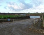 Toegang tot de recreatieplas vanaf de werkweg. Grondwater staat erg hoog zodat het idee ontstaat dat er al sprake is van een plas. Dat is echter niet zo. Tot eind maart is er alleen grondverzet. Dan liggen de contouren vast. Daarna wordt het grind weggehaald. Eind dit jaar moet de zaak klaar zijn. (16-1-2016 - Han Hamakers)