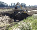Voor de opvulling van de werkweg wordt de voorheen in de vijver gestorte dekgrond weer gedeeltelijk afgegraven. (17-8-2016 - Jan Dolmans)